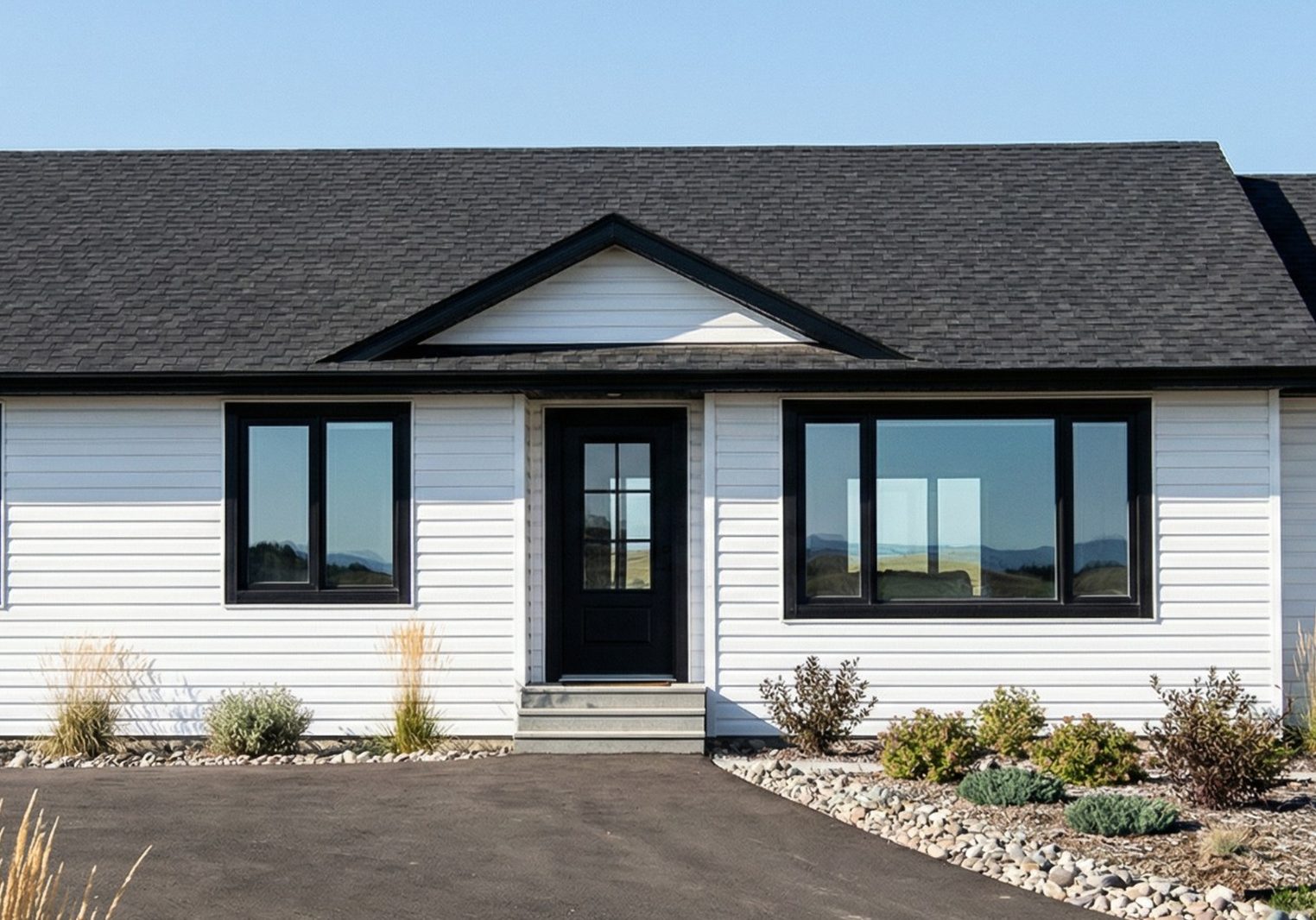 White bungalow with black trim, large front windows, and landscaped country lot